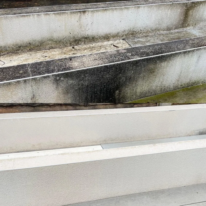 Concrete parapet on a commercial building cleaned, before and after