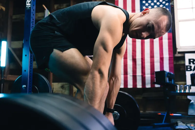 Jonathan deadlifting beside an American flag