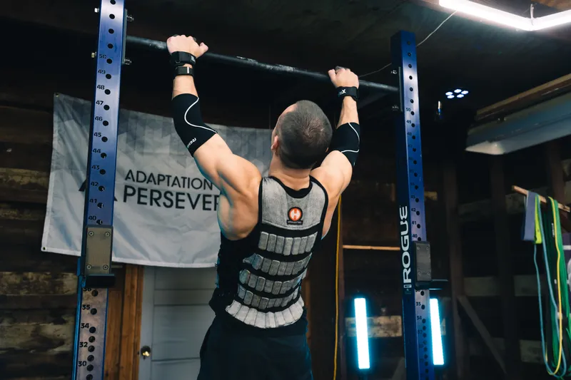 Jonathan doing weighted pull-ups, seen from behind