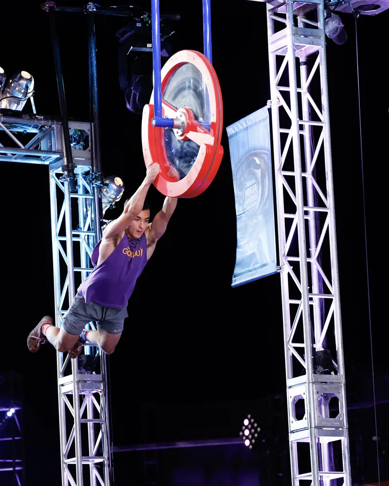 Jonathan swinging from a wheel obstacle