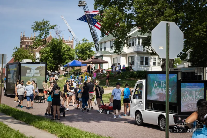 Two Legion 36 mini LED trucks at an outdoor community event with a crowd