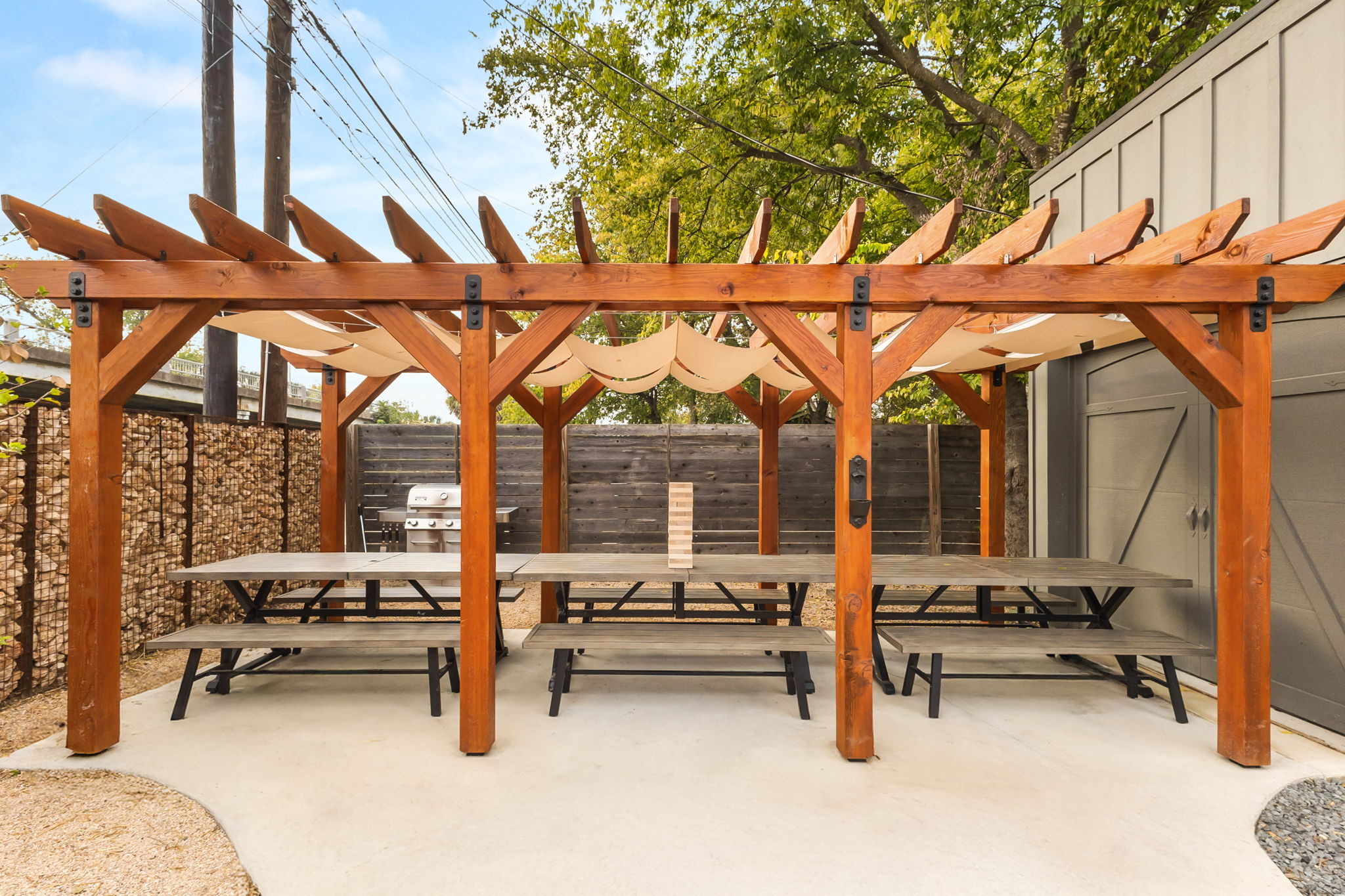 Custom cedar pergola with shade canopy over a patio dining area