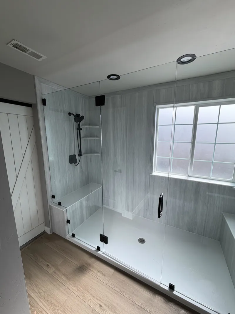 Frameless glass shower enclosure with black hardware