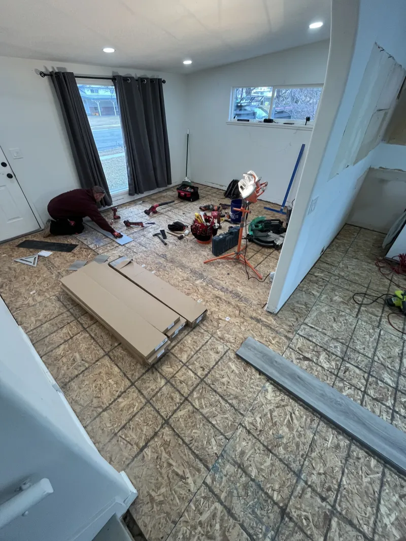Installer working on the subfloor before new planks go down