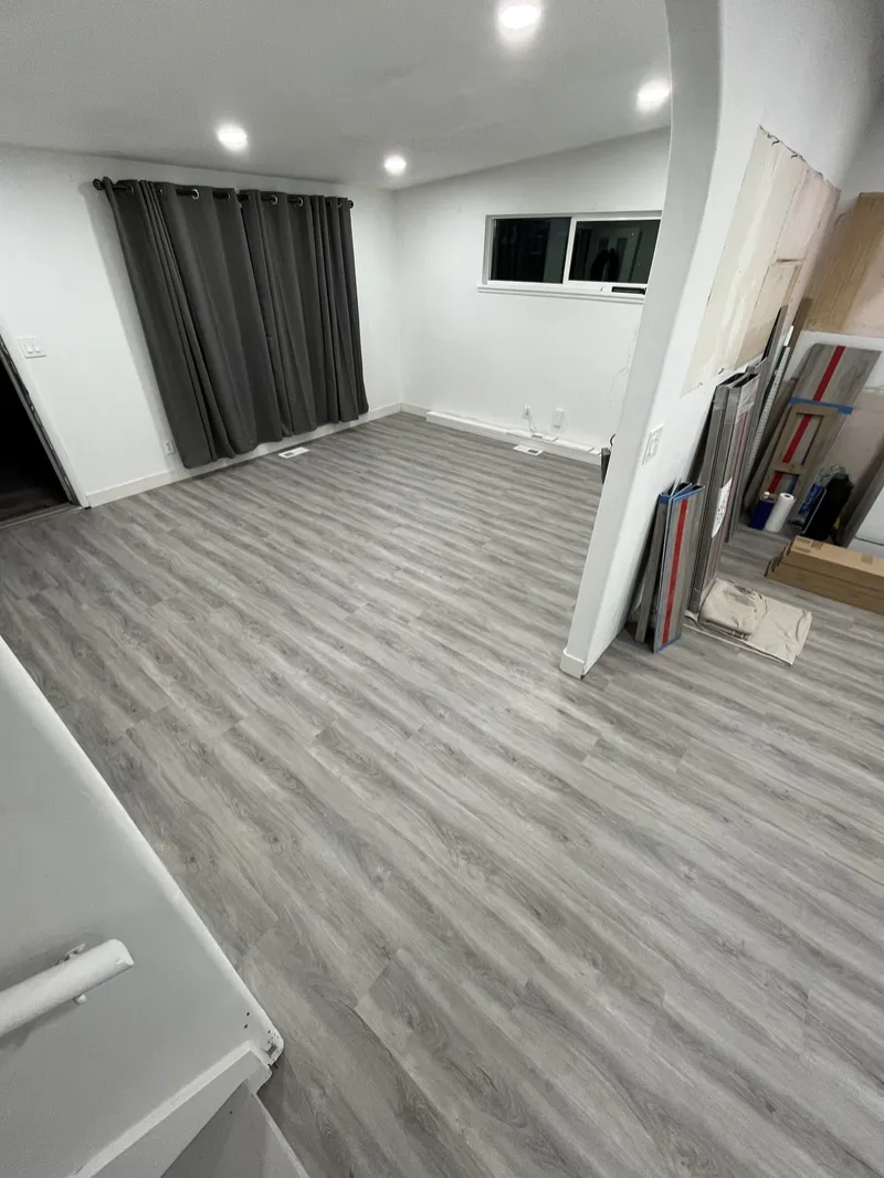 Finished basement room with gray plank flooring