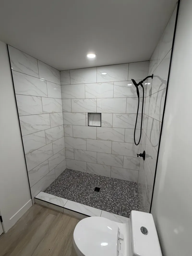 Tiled shower with niche and pebble floor