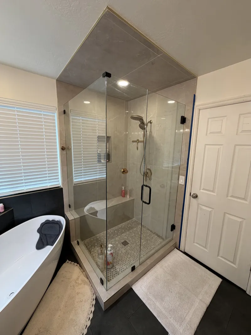 Frameless glass corner shower and freestanding tub