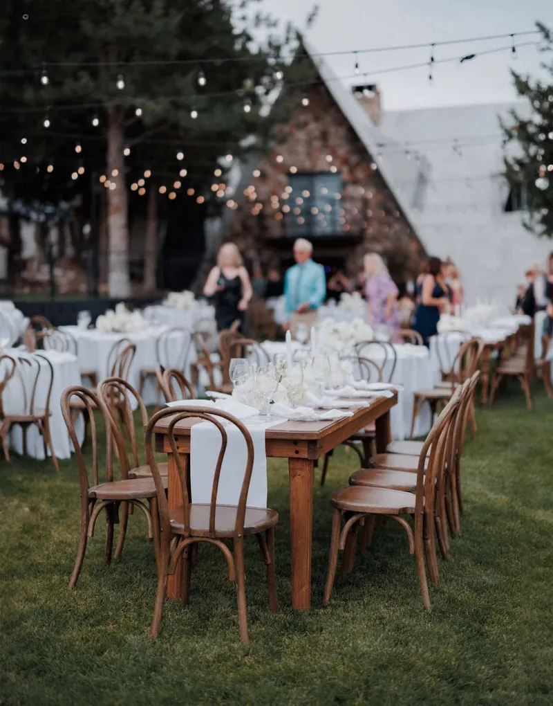 An outdoor table set for a celebration beside the stone building