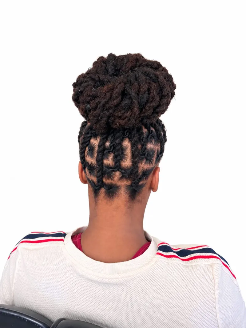 Palm roll locs styled in a high bun, back view