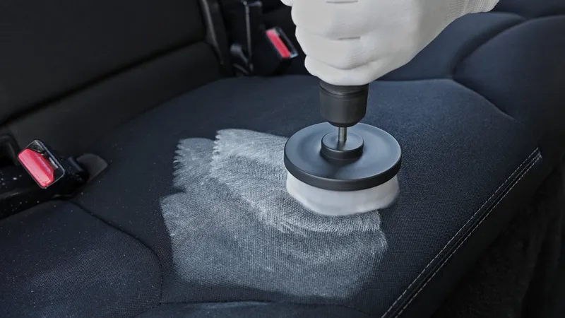 Drill brush shampooing a fabric car seat