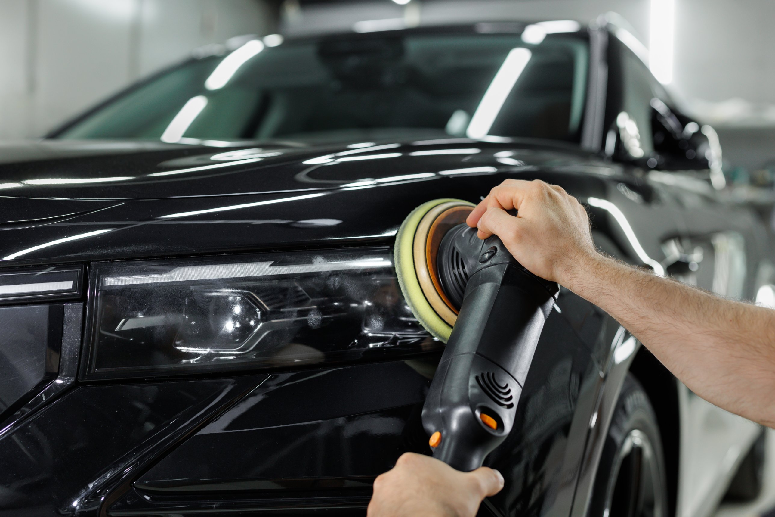 Dual-action polisher on a black hood