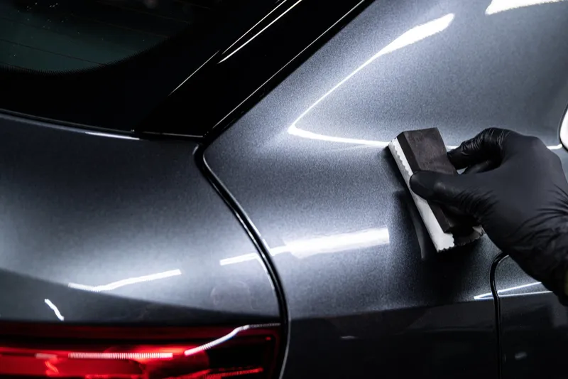 Applicator pad applying ceramic coating to grey paint