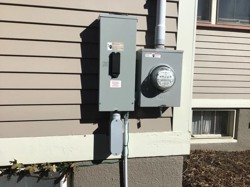 Exterior electrical meter and service equipment installed beside a home