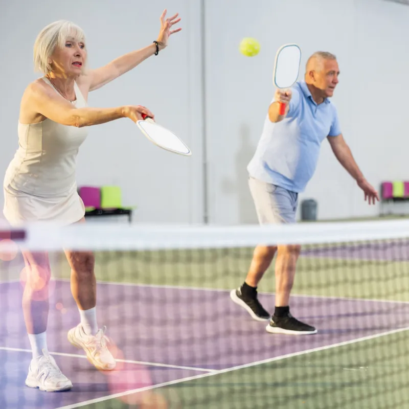 Two retirees playing pickleball