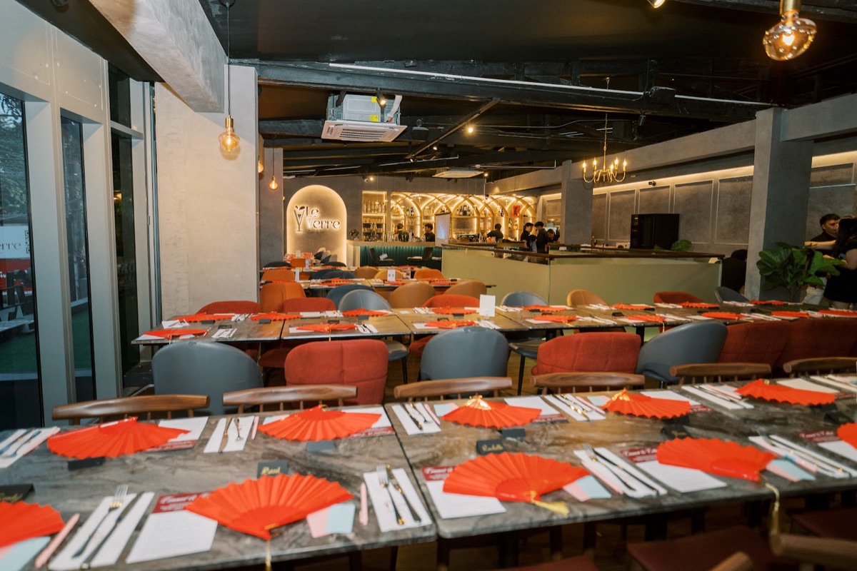 Long dinner tables set with red fans for FWIB members