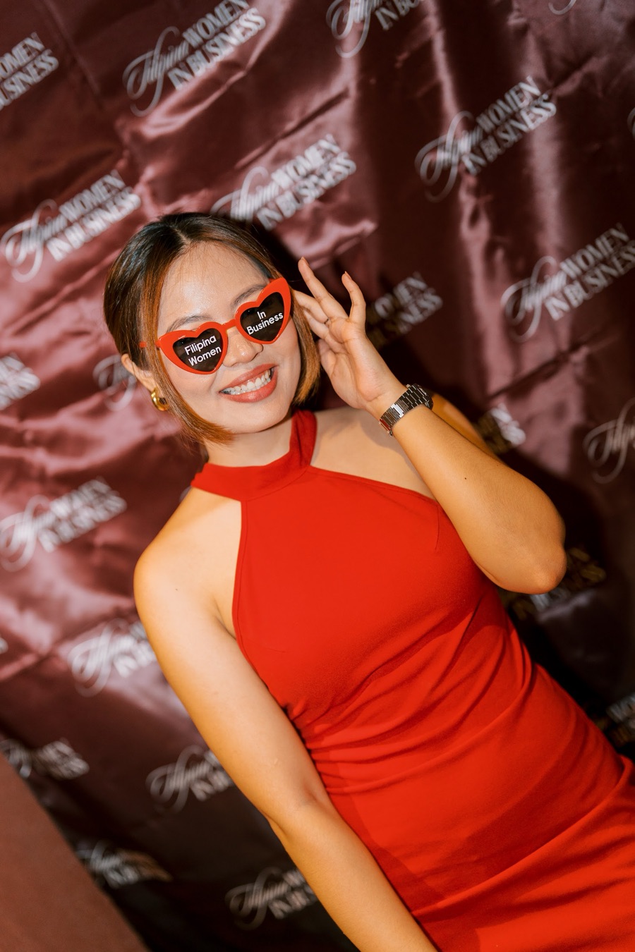 A member in red with heart sunglasses at the photo wall