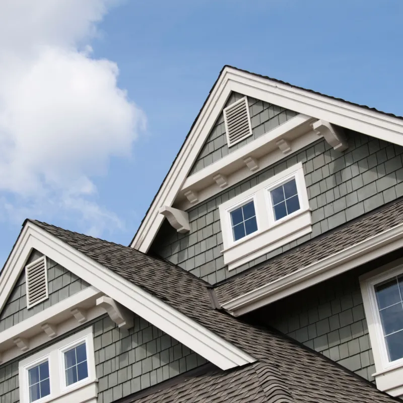Gabled two-story home with dimensional asphalt shingles and gray siding