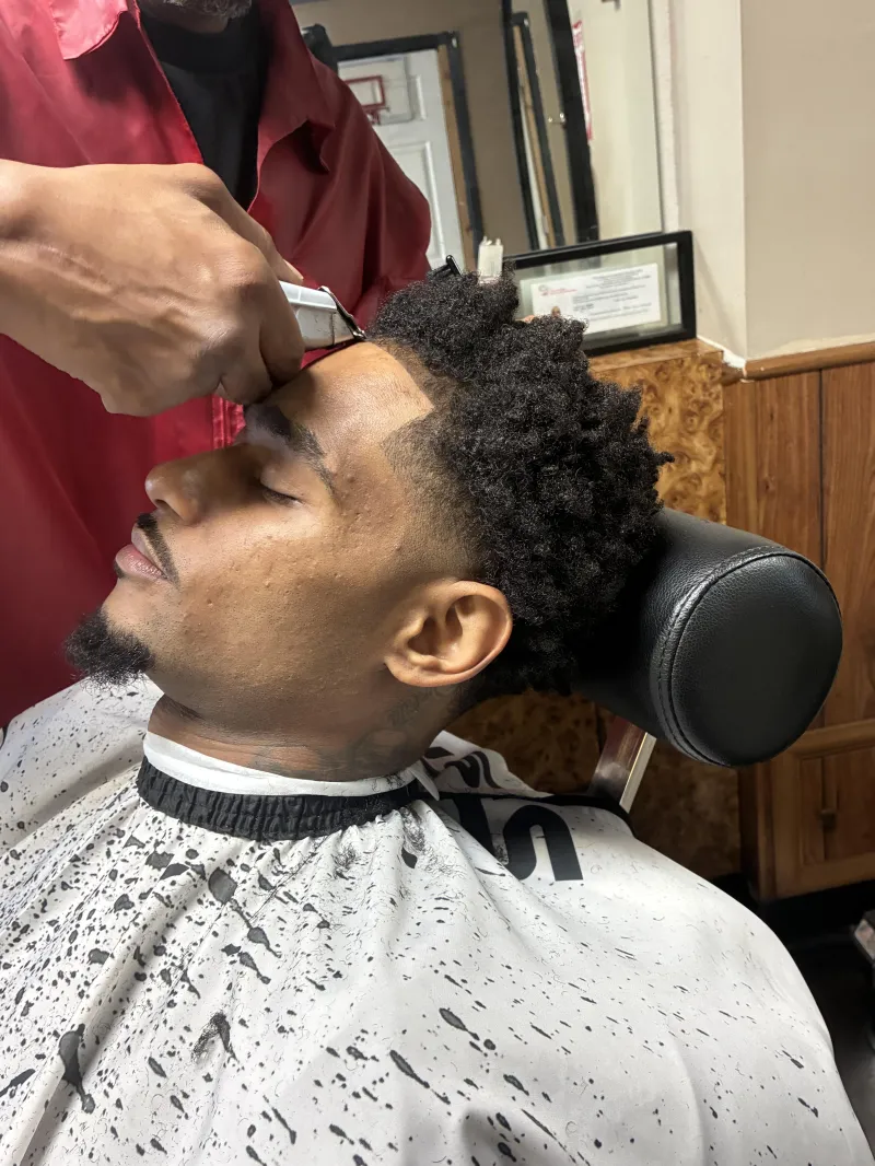 Barber shaping a beard with a straight razor