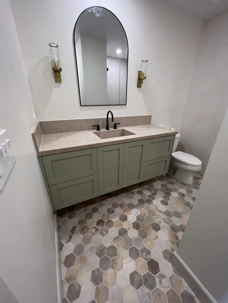 Sage green bathroom vanity over a hexagon tile floor