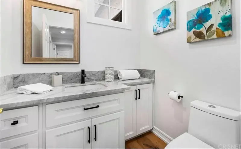 White shaker bathroom vanity with a gray stone top