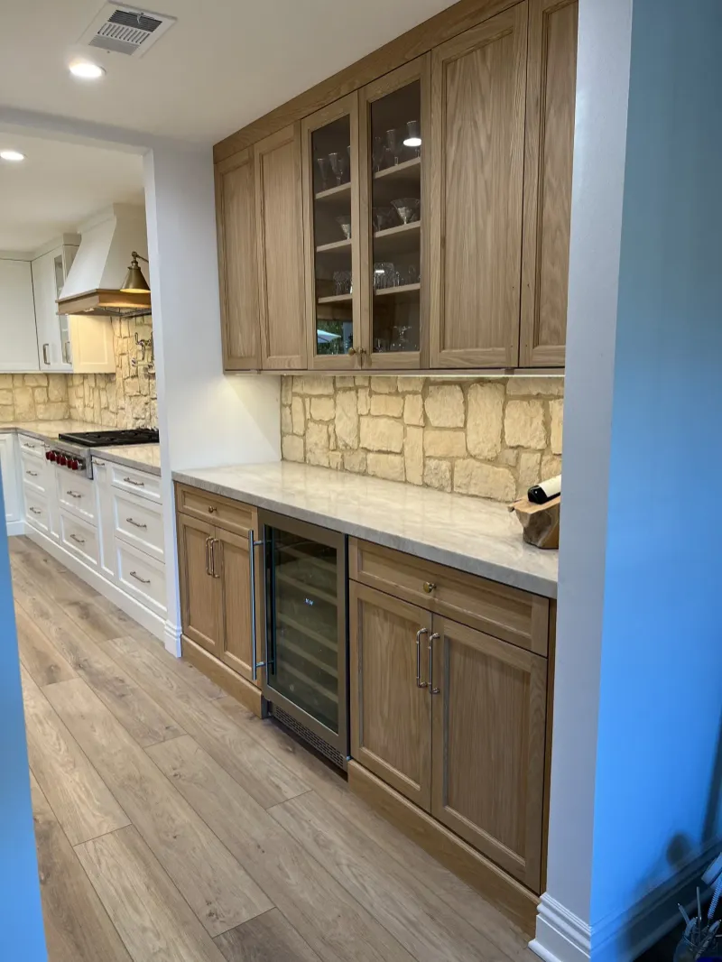 Oak bar wall with glass-front upper cabinets and a wine fridge
