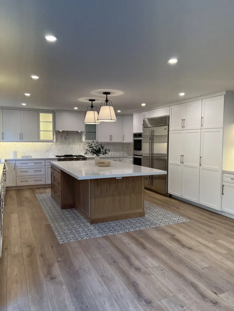 White kitchen with twin pendants over a white oak island