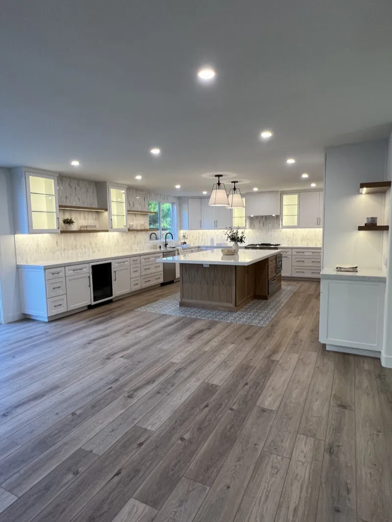 White kitchen with a white oak island and tall pantry wall