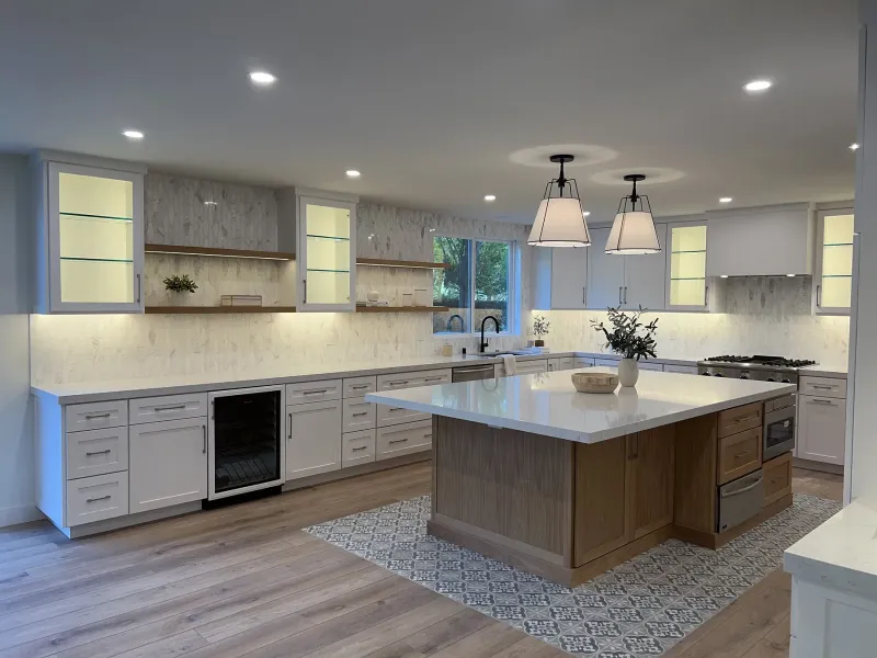 White oak island on a patterned tile rug inset under twin pendants
