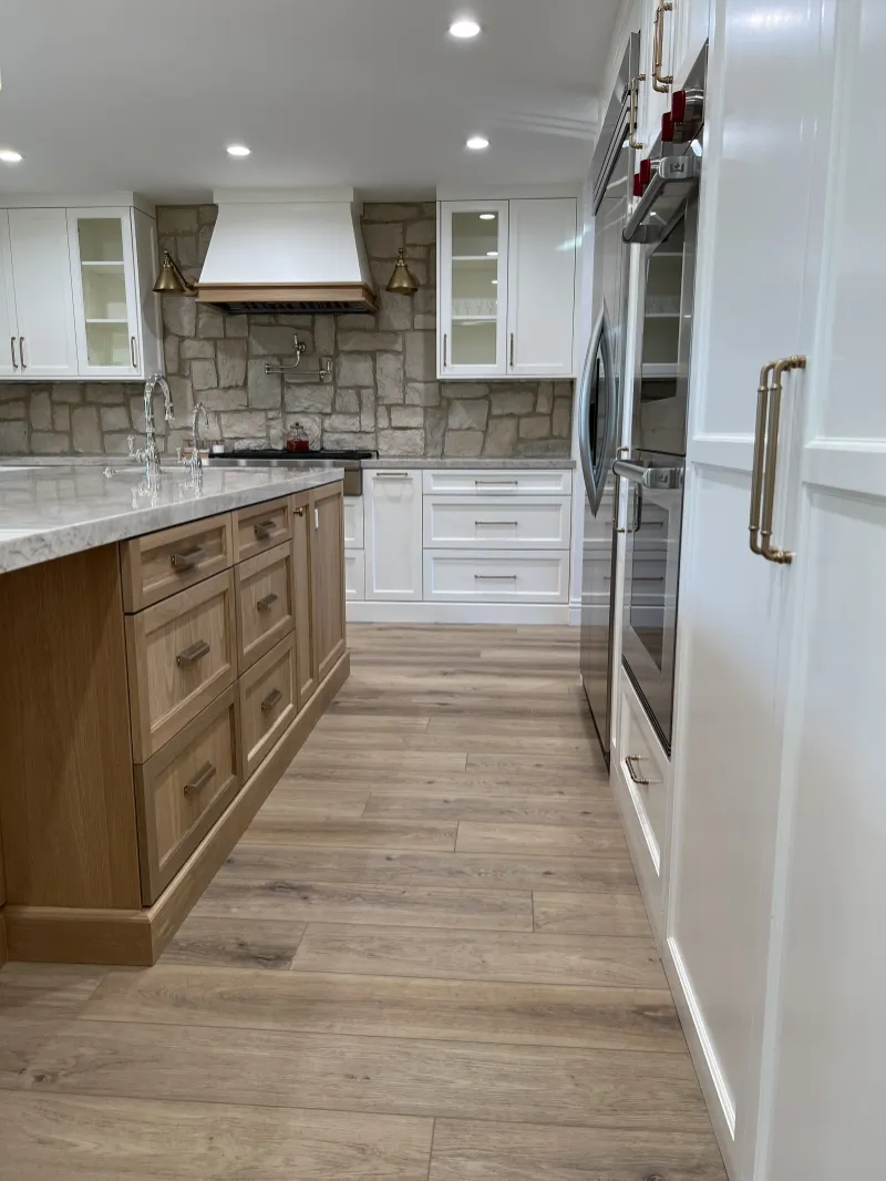 White oak island facing a wall of tall cabinets