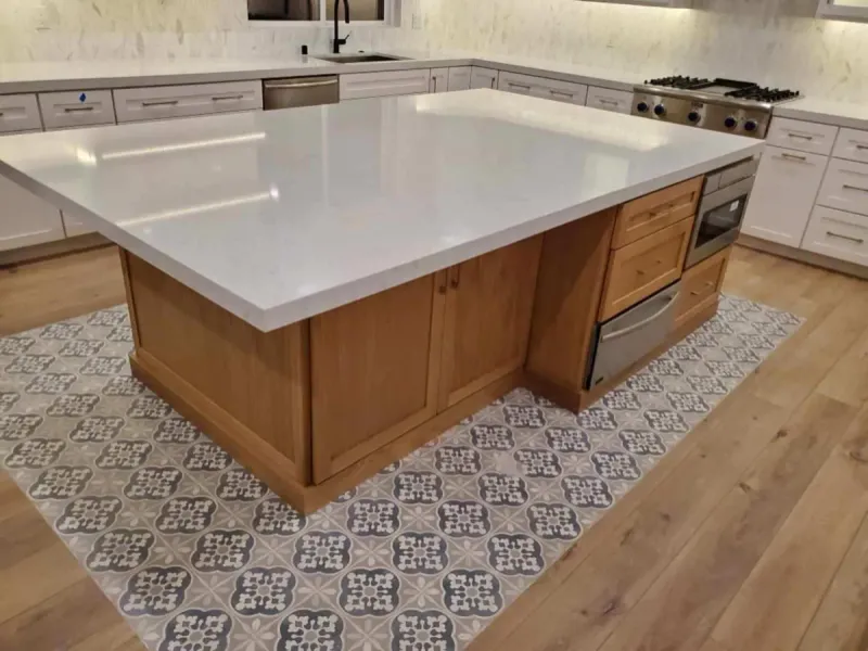 White oak island with a white top over a patterned tile inset