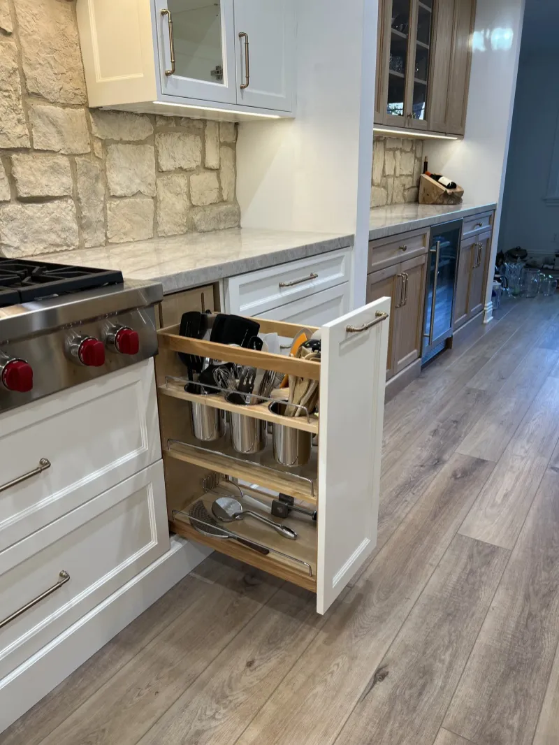 Pull-out utensil and spice storage beside a range