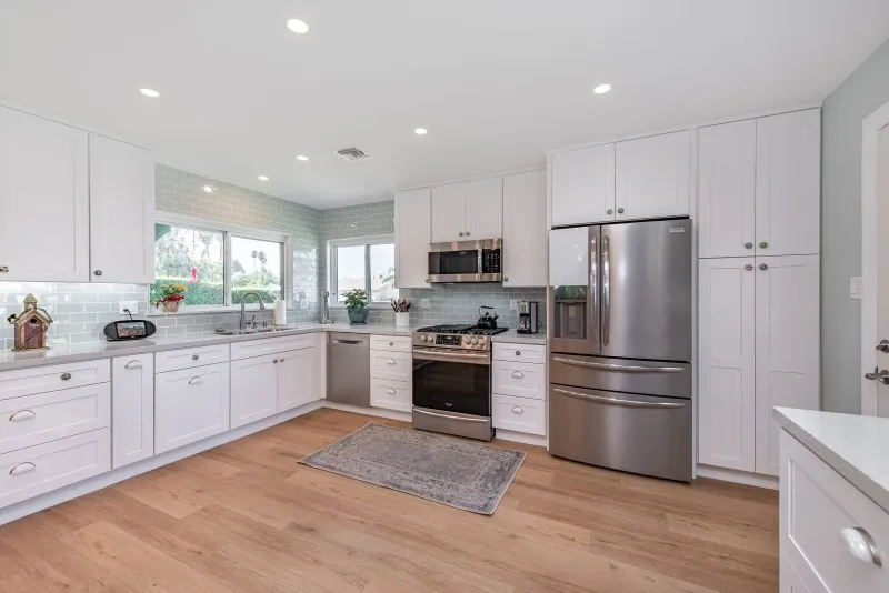 White shaker kitchen with stainless range and tall pantry cabinets