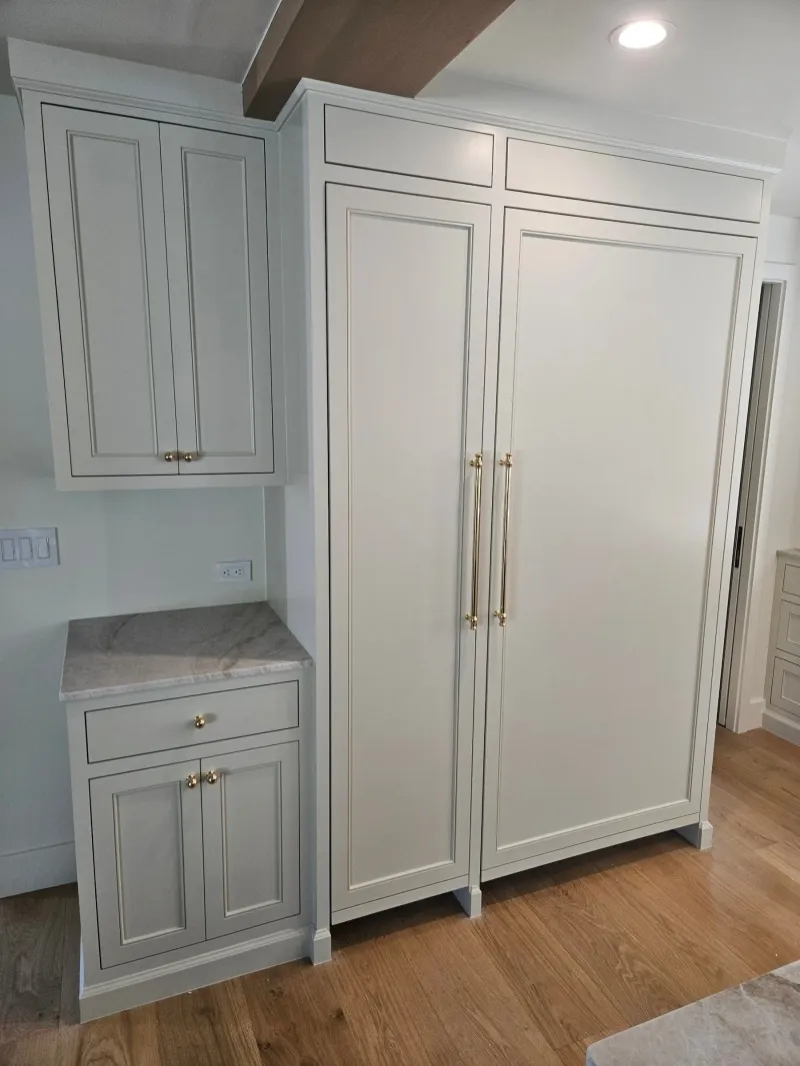 Painted panel-ready refrigerator surround with brass pulls