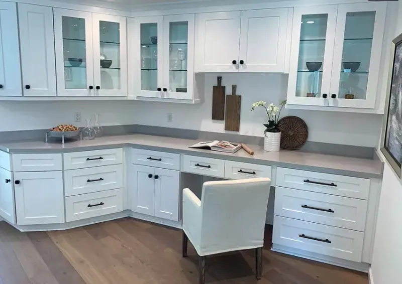 White L-shaped kitchen with glass-front upper cabinets