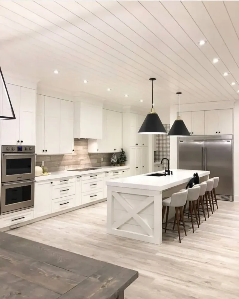 White kitchen with an island and black pendant lights
