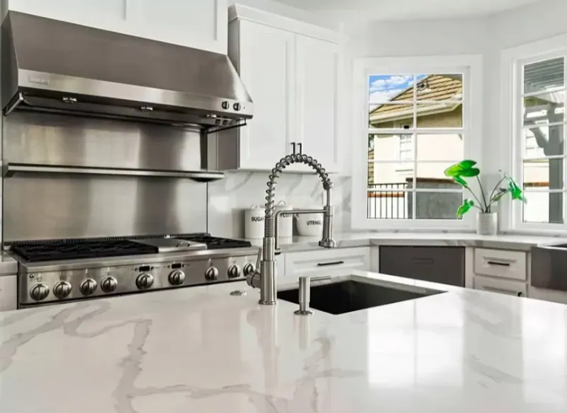 Professional range with white cabinets and stone counters