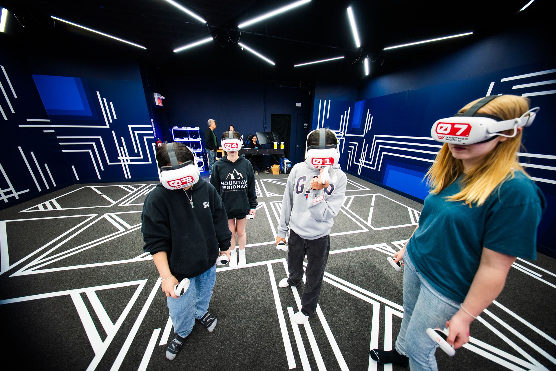 A student in a headset with classmates behind her