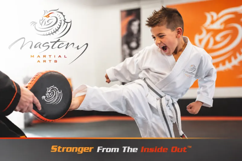 A child receiving patient encouragement from a Mastery Martial Arts instructor after becoming frustrated while learning a new skill.