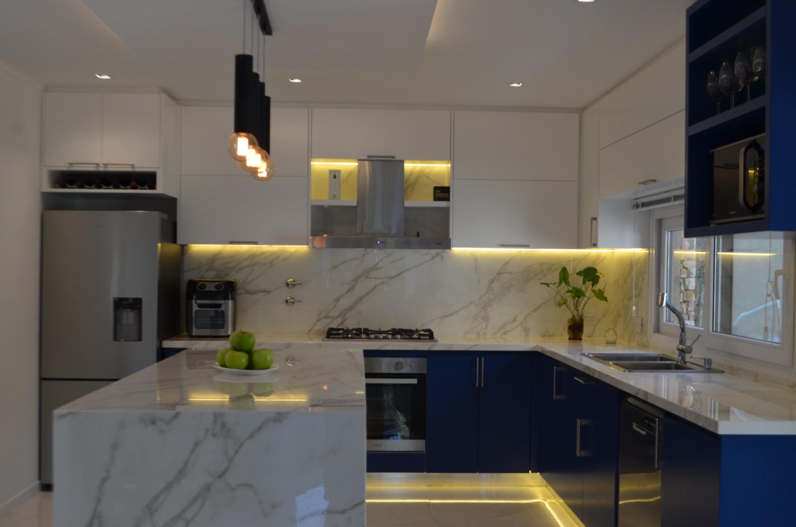 Cocina con mesada de mármol y muebles azules en Leloir