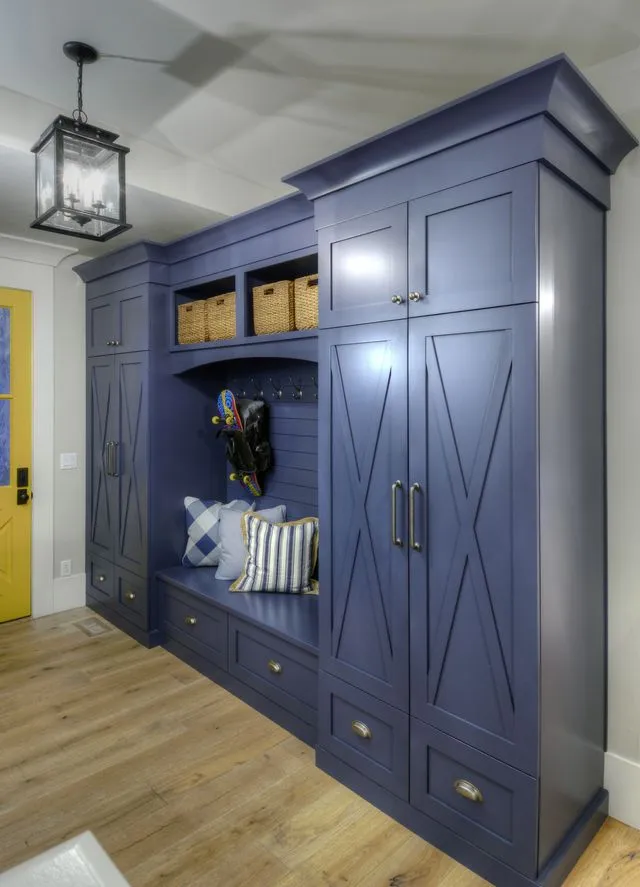 Navy blue mudroom cabinets with X-panel doors, a built-in bench and cubbies