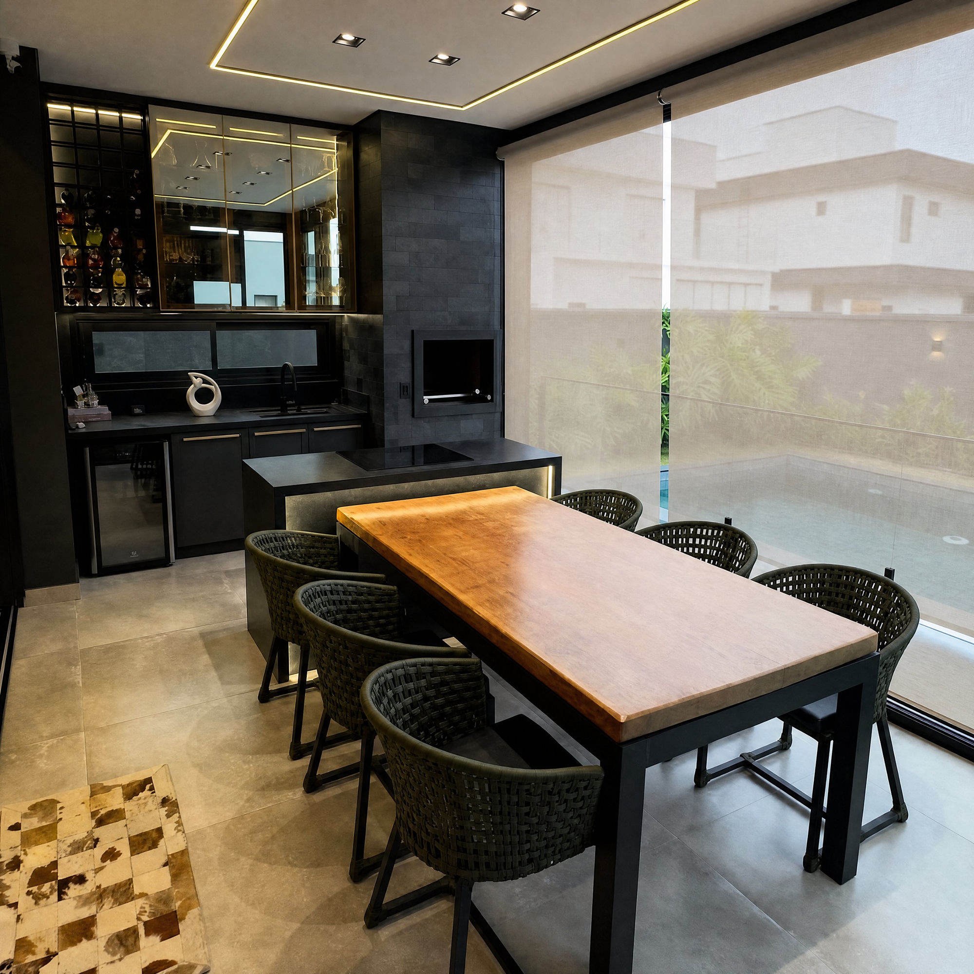 Área gourmet com cortina rolô (toldo cortina) protegendo do sol em casa contemporânea