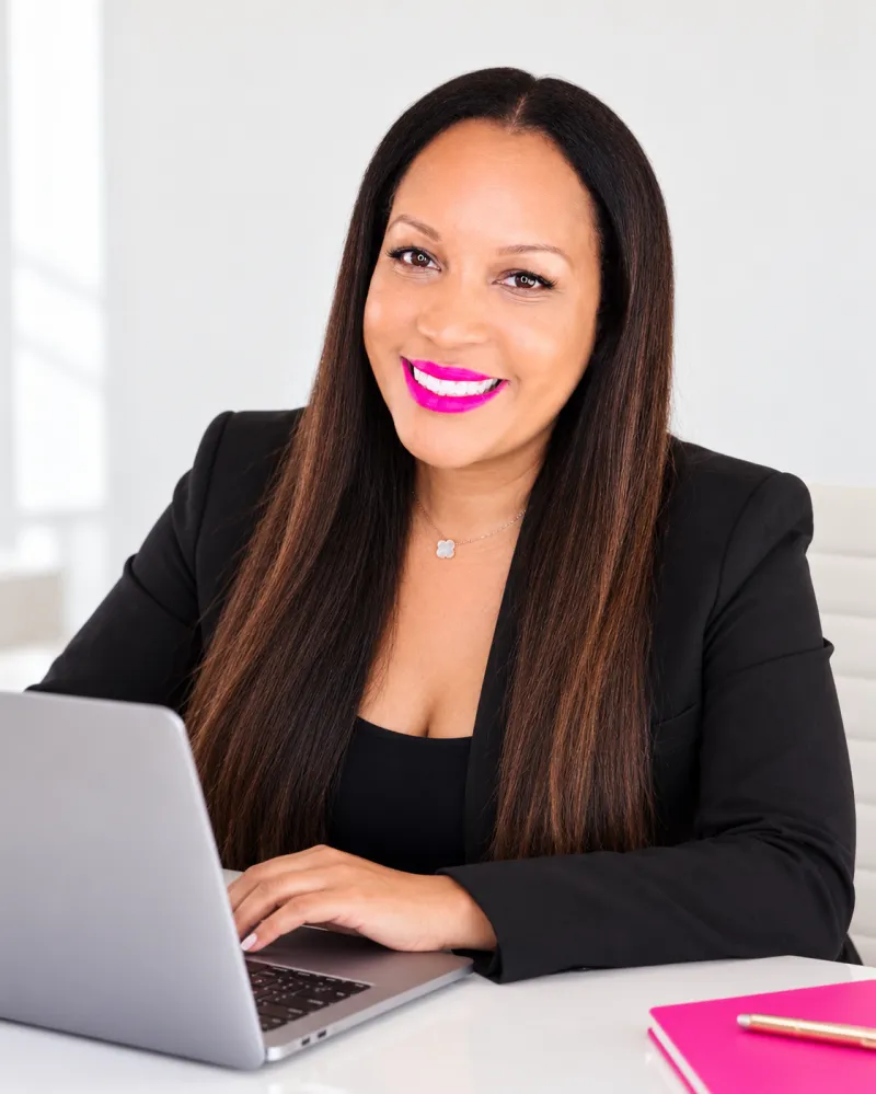 Starr Codd smiling at her desk with a laptop
