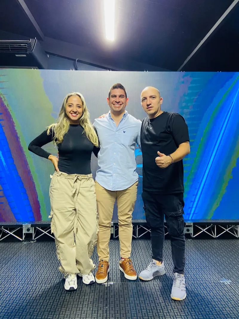 Mauricio Corzo junto a dos invitados en el escenario de un evento