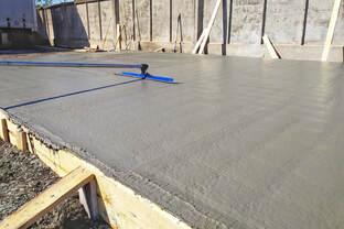 New concrete slab being bull floated for a flat, even finish in Aurora, Colorado