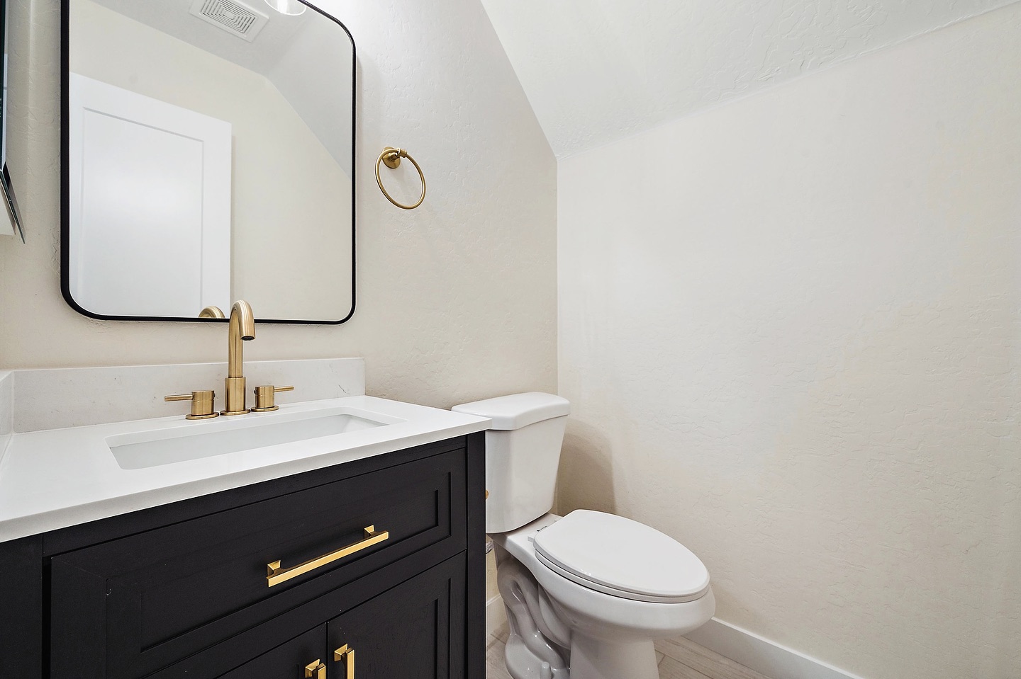 Modern bathroom with black vanity and gold fixtures Phoenix AZ