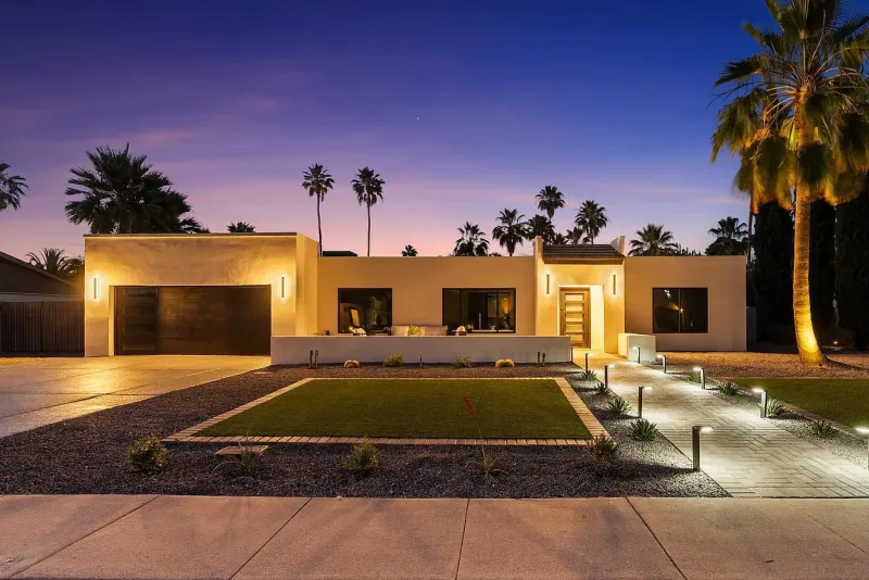 Luxury home at dusk with turf, pavers and concrete driveway — concrete work Phoenix AZ