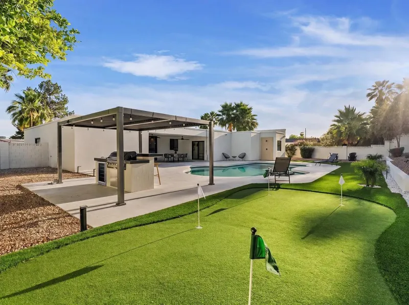 Outdoor kitchen with pergola, putting green and pool — outdoor living Phoenix AZ