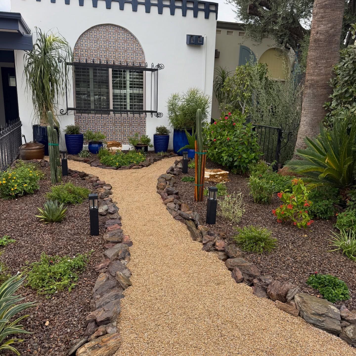 Flagship front yard close view: DG path, rock borders, blue accent pots, cacti and agave