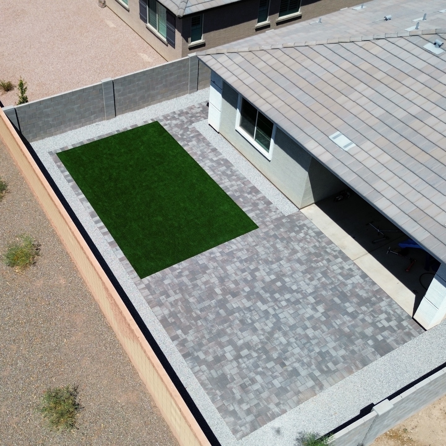 Aerial view of gray paver patio with turf inset, hardscaping in Phoenix AZ