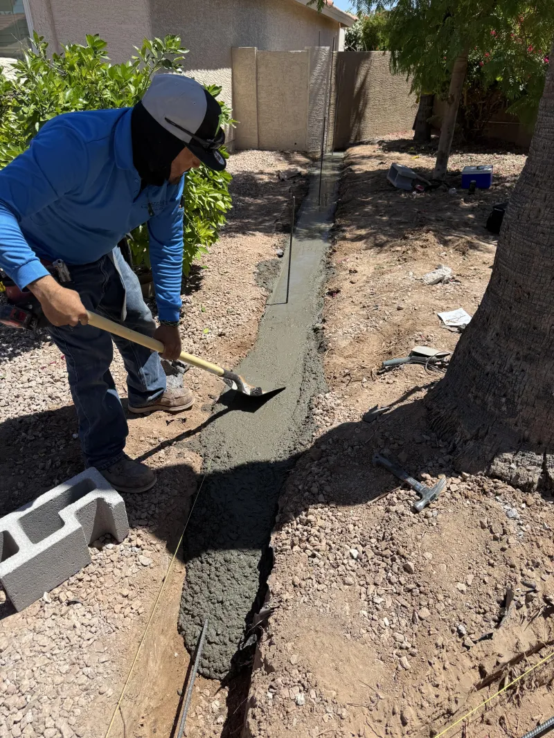 Crew finishing a freshly poured concrete footing for a block wall, concrete footings Phoenix AZ